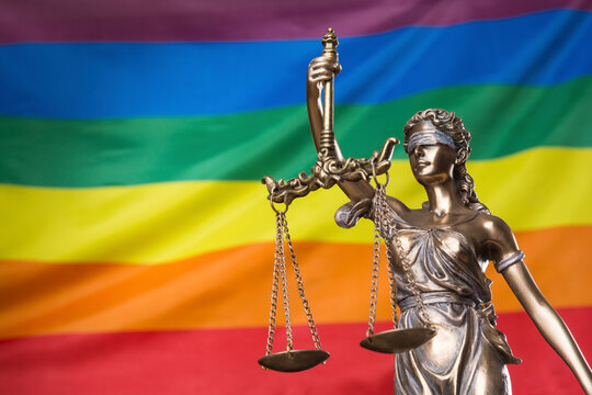The blindfolded goddess of justice Themis or Justitia against the rainbow flag of LGBT community, as a LGBT social issues concept