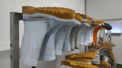 Industrial background of boots on the rack for factory workers to wear before going to line for...
