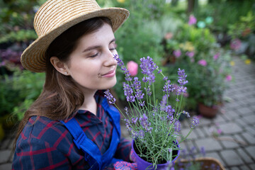 A worker sniffs flowering heather seedlings. Garden Shop.