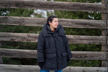 Chica joven guapa en la nieve posando feliz ante la cámara y poniendo caras graciosas