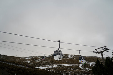 Paraje natural nevado con telefericos y pueblo de fondo