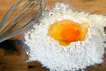 Egg and Flour with Wisk on Wooden Table
