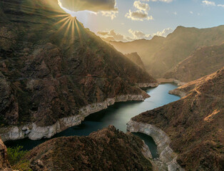 parralillo reservoir in gran canaria canara islands with beautiful sunset and beautiful reflections of the sun with afternoon mist and winter weather with beautiful colors and plenty of water due to t