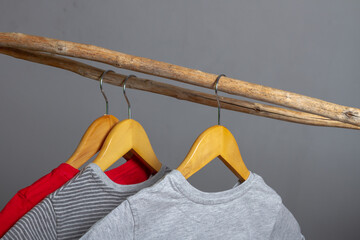 Clothes made of natural cotton hang on wooden hangers on a crossbar made of a stick. The concept of...