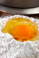 One Egg in Flour on Wooden Table Surface