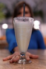 A vertical shot of a young woman having a drink inside a charming cafe. Having drinks with a friend in a spectacular place. Enjoying a freshly smoothie.