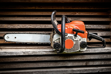Chainsaw after work on the background of the boards