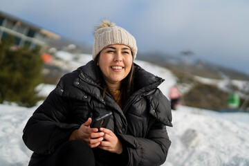 Chica joven guapa en la nieve haciéndose selfies mientras sonríe