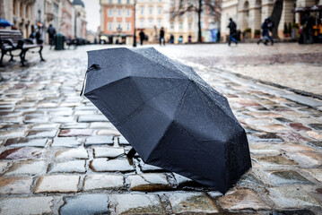 umbrella standing on wet stone pavement
