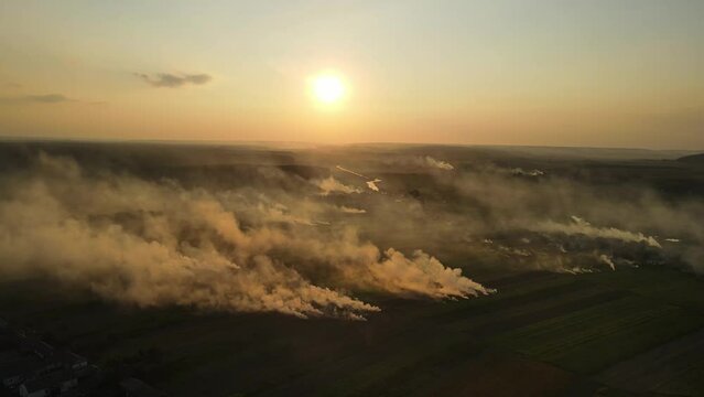 Aerial shot in Ukraine at sunset, burning grass. Emissions into the atmosphere