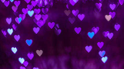 Bokeh background with purple hearts on black background. Love concept. Theme for Valentine's Day