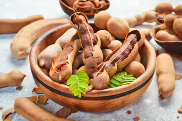 fresh sweet ripe tamarind with leaf, healthy fruit. Side view. On a stone background.