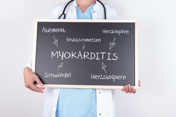 Ärztin mit einer Tafel zur Myokarditis und möglichen Symptomen