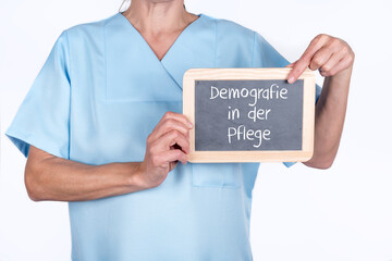 Krankenschwester oder Altenpflegerin mit einer Tafel auf der Demografie in der Pflege steht