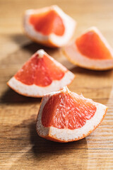 Sliced citrus fruit. Chopped fresh grapefruit on wooden table.