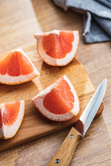 Sliced citrus fruit. Chopped fresh grapefruit on cutting board.