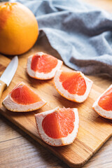 Sliced citrus fruit. Chopped fresh grapefruit on cutting board.