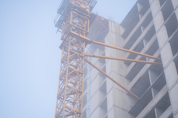 Multi-storey house construction process on a foggy autumn morning. Construction process concept