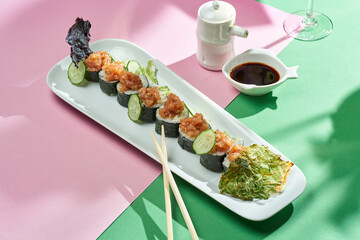 Sushi roll with tuna and cucumber in a plate of bright backgrounds. Selective focus, hard shadows