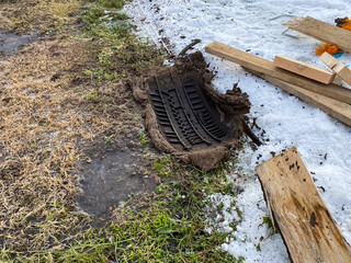 Car tires tread feet in the spring. Stuck car tire footprint, with wooden boards next to it....