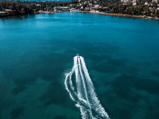 Aerial photo of extreme power boat water-sports cruising in high speed in deep blue corfu island greece