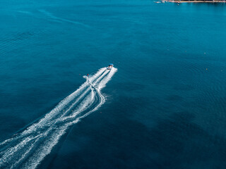 Aerial photo of extreme power boat water-sports cruising in high speed in deep blue corfu island greece