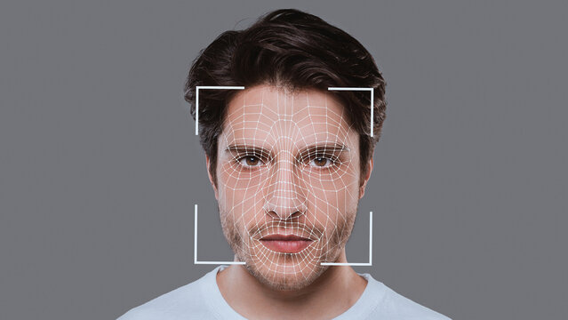 Portrait of young guy on grey, having face recognition