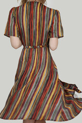Woman in funky multicolor striped wrap midi dress. Studio shot.