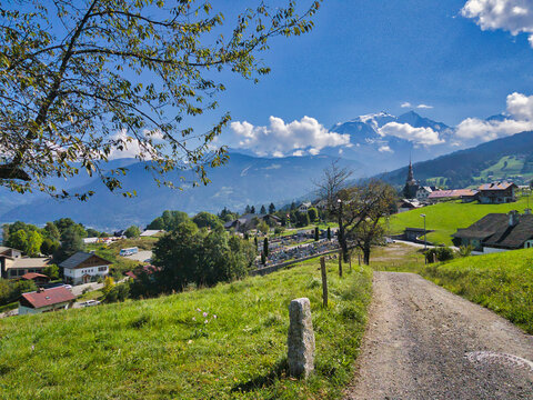 Panoramic view of the pastures and houses of Combloux, Haute-Savoie, France. In the background the snowy peaks of the Mont Blanc.