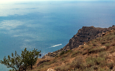 Mountain landscape. A motorboat can be seen in the distance. 