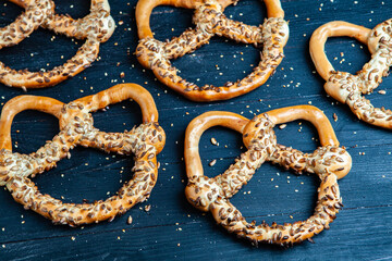Fresh prepared homemade soft pretzels. Different types of baked bagels with seeds on a black background.