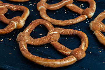 Fresh prepared homemade soft pretzels. Different types of baked bagels with seeds on a black background.
