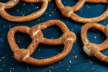 Fresh prepared homemade soft pretzels. Different types of baked bagels with seeds on a black background.