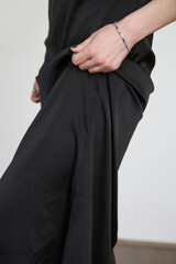 Woman in black silk satin camisole dress, studio shot.