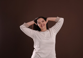 Beautiful overweight woman with charming smile on brown background