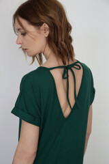 Woman in casual pine green stretch cotton midi dress.T shirt dress made from organic cotton. Studio shot.