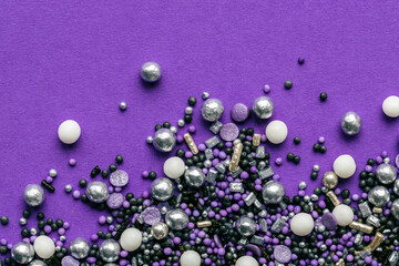 lila und silberfarbene Zuckerstreusel auf lila Hintergrund