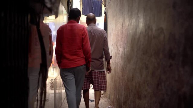 poor peope of dharavi walking from narrow lane to market