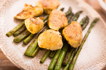cooked dish. Chicken nuggets with green asparagus on plate