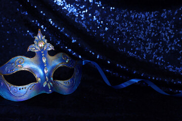 Photo of elegant and delicate Venetian mask over blue dark background