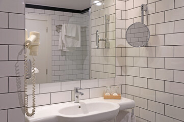 cuarto de baño azulejo blanco con lavabo y espejo hotel 4M0A0203-as22