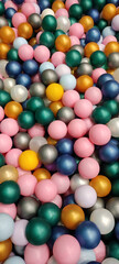 bright festive multicolored plastic small balls are scattered in the form of a colored background