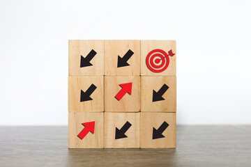 Woodblock cubes with arrow. Red arrow facing the opposite direction from black arrows and head towards the target. Disrupt, Difference thinking concept. - obrazy, fototapety, plakaty