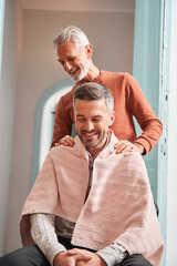 Vertical view of the mature man helping his son to cut hair at home