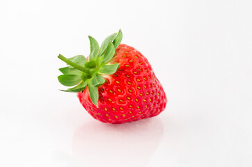 Fresh organic strawberries on a white reflective surface. Close up shot.