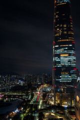 Obraz premium Jamsil buildings and Seokchon lake at night, Jamsil, Songpa-gu, Seoul, South Korea. Vertical view.