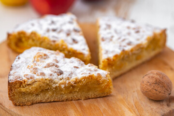 apple and nuts pie on wooden desk on white table