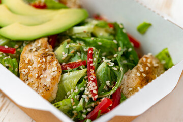 chicken salad with avocado in a Take away box. Healthy lunch