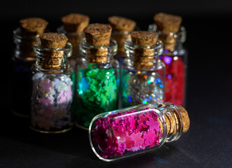Colorful group of glass bottles on black background