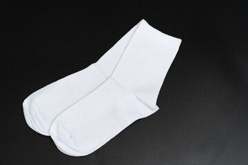 A pair of short white socks on a black background. accessories for men and women. clothing store.